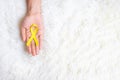 Hand holding Yellow Ribbon on white background for supporting people living and illness. September Suicide prevention day, Royalty Free Stock Photo