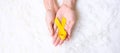 Hand holding Yellow Ribbon on white background for supporting people living and illness. Suicide prevention day, Sarcoma cancer Royalty Free Stock Photo