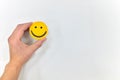 A hand holding a yellow smiley face on a white background. Satisfied customer, positive feedback and good service concepts Royalty Free Stock Photo