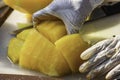 Hand holding yellow watermelon And use a knife to cut a piece Royalty Free Stock Photo