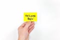 Hand holding a yellow welcome back note card. Back to work, office and school concept. Royalty Free Stock Photo