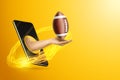 Hand holds American football ball via smartphone on yellow background. Concept for online games, sports broadcasts, sports betting