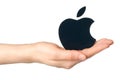 Hand holds apple logotype printed on paper on white background