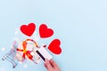 A hand holds a bank card above a shopping cart with a gift box and red love hearts on a blue background, copy space Royalty Free Stock Photo