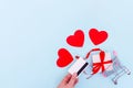 A hand holds a bank card above a shopping cart with a gift box and red love hearts on a blue background, copy space Royalty Free Stock Photo