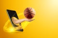 Hand holds a basketball ball through a smartphone on a yellow background. Concept for online games, sports broadcasts, sports Royalty Free Stock Photo