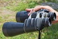 Hand holds big black binoculars on the street Royalty Free Stock Photo
