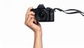 Hand holding a black DSLR camera with a strap on a white background DSLR digital Royalty Free Stock Photo
