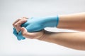 Hand holds a hand in a blue medical glove on a white background. crossed fingers hands. prayer. Horizontal orientation Royalty Free Stock Photo