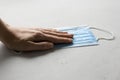 Hand holds blue medical masks. Disposable masks for protection lie on white background. Typical surgical mask to cover mouth, nose