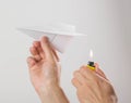 A hand holds a burning paper airplane. Close up. Isolated on a gray background Royalty Free Stock Photo