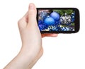 Hand holds cellphone with Xmas decorations Royalty Free Stock Photo