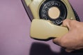 Hand holds classic telephone receiver. vintage phone with handset on color background. old communication technology Royalty Free Stock Photo