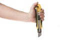 Hand holds a construction knife on a white background, a template for designers. Royalty Free Stock Photo