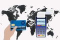 Hand holds a credit card near the payment terminal on the background of the world map. Contactless payment concept Royalty Free Stock Photo