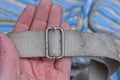 hand holds a dirty white harness with gray metal clasp Royalty Free Stock Photo