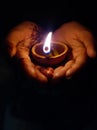 A hand holds diya image, beautiful lighting in dark