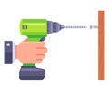 a hand holds a drill and twists a bolt into a tree. construction tool for housework.