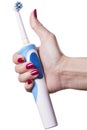 Hand holds electric toothbrush against white Royalty Free Stock Photo