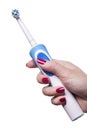 Hand holds electric toothbrush against white Royalty Free Stock Photo