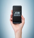 A hand holds a fancy smartphone. Words: ' Job search ' on the screen. A concept of recruitment.