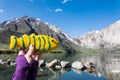 Hand holds a fish shaped decorated sugar cookie in front of Convict Lake, a popular fishing destination in California Royalty Free Stock Photo