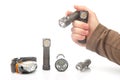 hand holds a flashlight against the background of other flashlights on a white background. camping and household item