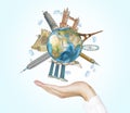 A hand holds a globe with sketched the most famous places in the world. A concept of tourism and sightseeing. Light blue backgroun