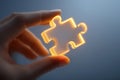 Hand holds glowing puzzle piece symbolizing creativity and problem-solving in a serene setting Royalty Free Stock Photo
