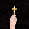 Hand holds a golden cross on black background