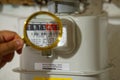 hand holds a golden magnifying glass and zoom display of the gas meter