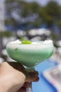 Hand holds green cocktail in a beautiful glass with ice cream an Royalty Free Stock Photo