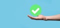 Hand holds green icon Check mark,Check Mark Sign, Tick Icon,right sign,circle green checkmark button,Done.On dark background. Royalty Free Stock Photo