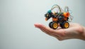 Hand holds handmade robot on white background promoting STEM education. Robot is built on the Arduino platform. Perfect image for