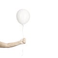 Hand holds his white balloon tight as it tries to escape
