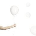 Hand holds his white balloon tight as it tries to escape
