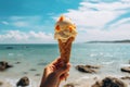 Hand holds ice cream with a sea backdrop Summer delight Royalty Free Stock Photo