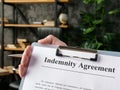 Hand holds indemnity agreement for signing in the office.