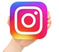 Hand holds Instagram icon on white background