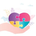 Hand holds jigsaw puzzle in form of heart. Heart made from puzzle pieces of different colors Royalty Free Stock Photo