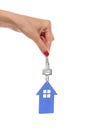 Hand holds key with a keychain the shape of house. Royalty Free Stock Photo