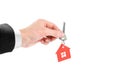 The hand holds the keys with the red house keychain. Purchase of apartments. House in hands. Close up. Isolated on a white Royalty Free Stock Photo