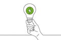 A hand holds a lightbulb with a green lightning bolt inside, symbolizing bright ideas concept Royalty Free Stock Photo