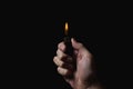 Hand holds a lighter on a black background. Royalty Free Stock Photo