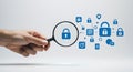 A hand holds a magnifying glass focusing on a blue padlock icon, symbolizing