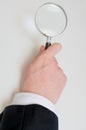 Hand holds magnifying glass. Isolated on white background