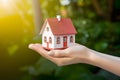 Hand holds miniature house, dreams of home ownership, in grasp Royalty Free Stock Photo