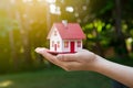 Hand holds miniature house, dreams of home ownership, in grasp Royalty Free Stock Photo