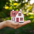 Hand holds miniature house, dreams of home ownership, in grasp Royalty Free Stock Photo
