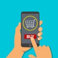 Hand holds mobile phone with buy button in shop.Finger clicks touch screen to pay of online purchases. Customer conducting payment Royalty Free Stock Photo